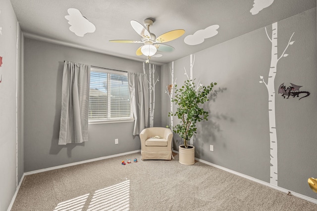 sitting room featuring carpet and ceiling fan