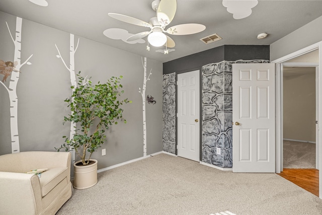 interior space featuring ceiling fan and carpet