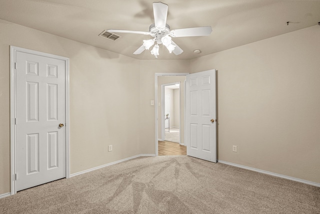 empty room with light colored carpet and ceiling fan