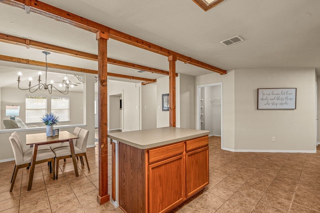 kitchen featuring pendant lighting, light tile patterned floors, a center island, and an inviting chandelier