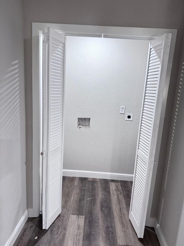 laundry area featuring dark wood-type flooring and hookup for an electric dryer