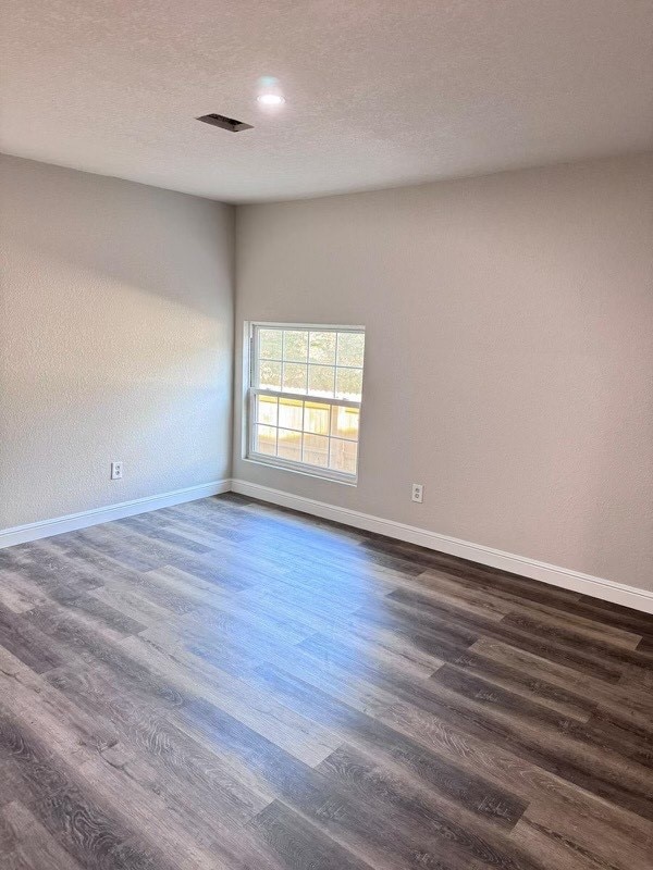 unfurnished room with dark hardwood / wood-style floors