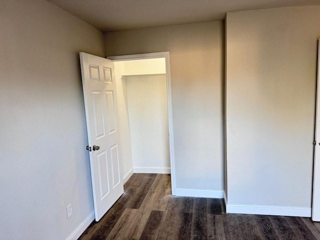 unfurnished bedroom with dark wood-type flooring