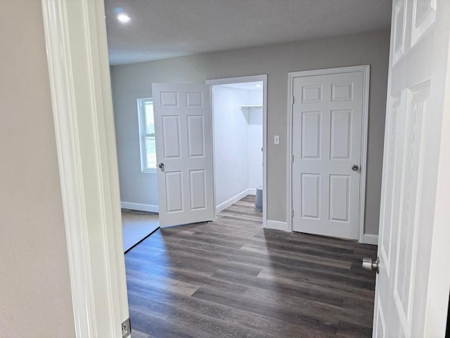 hallway featuring a textured ceiling and dark hardwood / wood-style flooring