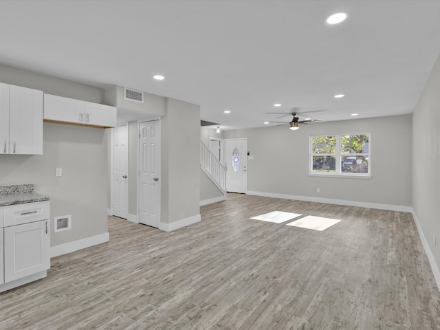 unfurnished living room featuring light wood-type flooring and ceiling fan