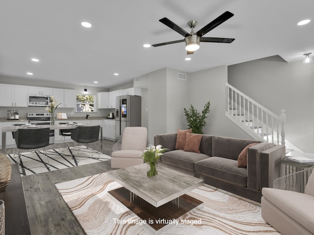 living room featuring light wood-type flooring and ceiling fan