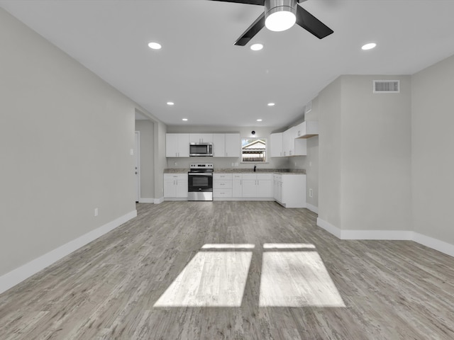 kitchen featuring white cabinets, ceiling fan, appliances with stainless steel finishes, light hardwood / wood-style floors, and sink