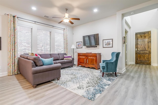 living room with ceiling fan and light hardwood / wood-style flooring