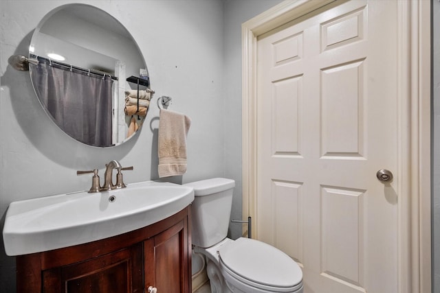 bathroom with vanity, toilet, and curtained shower