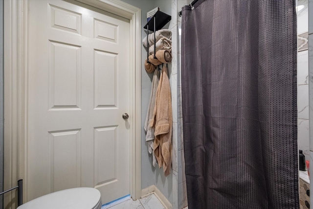 bathroom featuring curtained shower and toilet