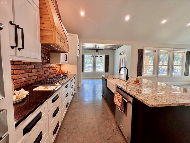 kitchen with appliances with stainless steel finishes, sink, hanging light fixtures, a large island, and white cabinetry