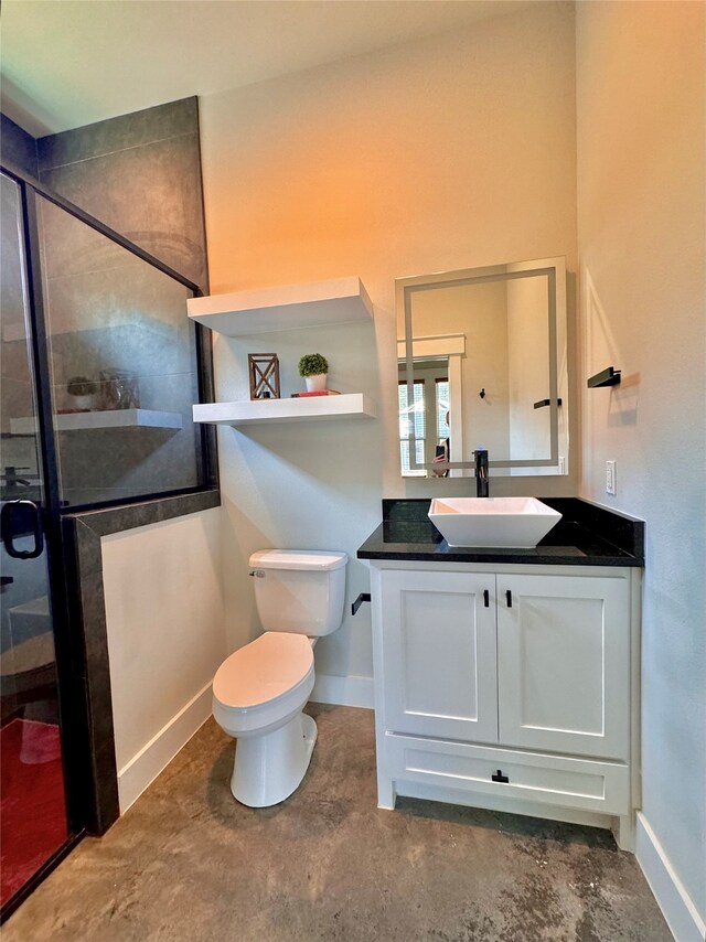 bathroom featuring vanity, a shower with shower door, concrete flooring, and toilet