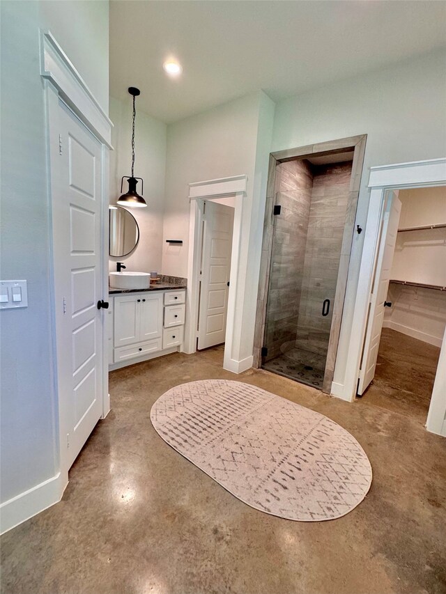 bathroom with vanity, an enclosed shower, and concrete flooring