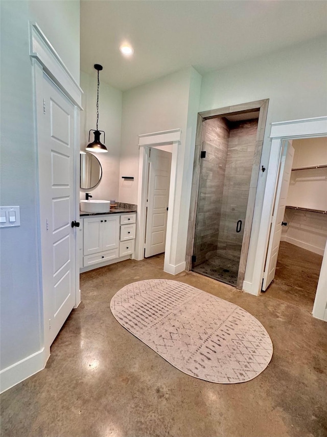 166 Oak Ridge Loop, Whitney, TX 76692 - full bathroom featuring concrete flooring, a stall shower, vanity, a spacious closet, and baseboards