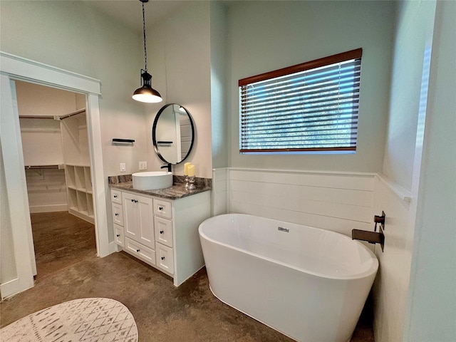 166 Oak Ridge Loop, Whitney, TX 76692 - bathroom featuring vanity, a soaking tub, a walk in closet, and a wainscoted wall