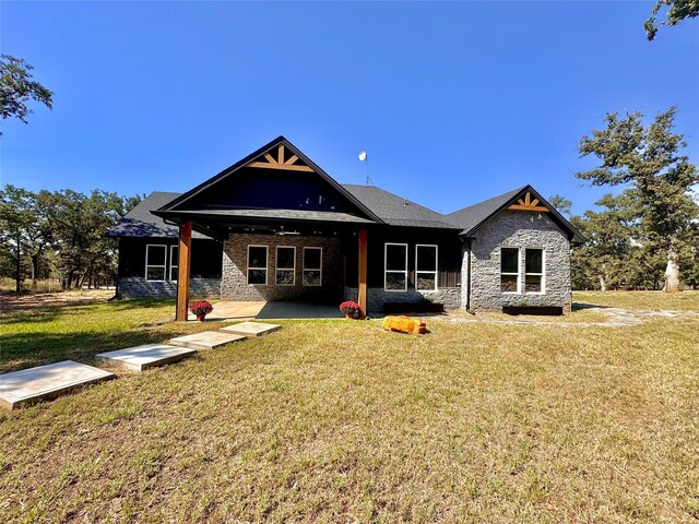 back of property with a yard and a patio