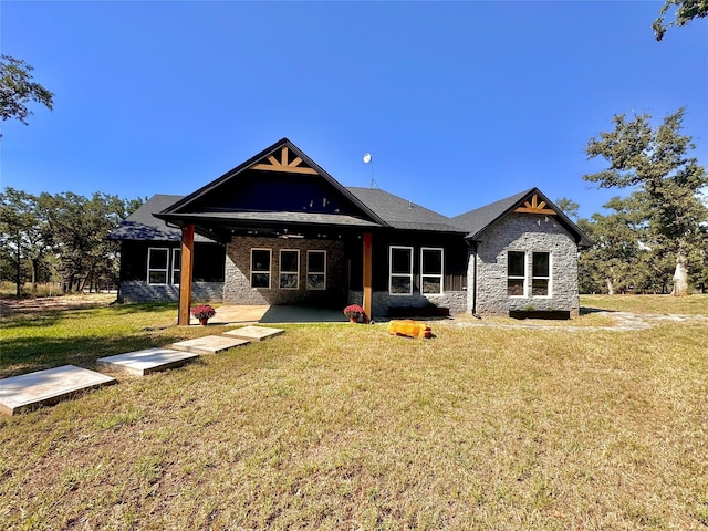 166 Oak Ridge Loop, Whitney, TX 76692 - back of property featuring a lawn, a patio area, and stone siding