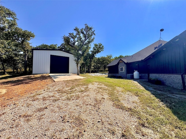 166 Oak Ridge Loop, Whitney, TX 76692 - view of yard featuring an outbuilding, driveway, and a detached garage