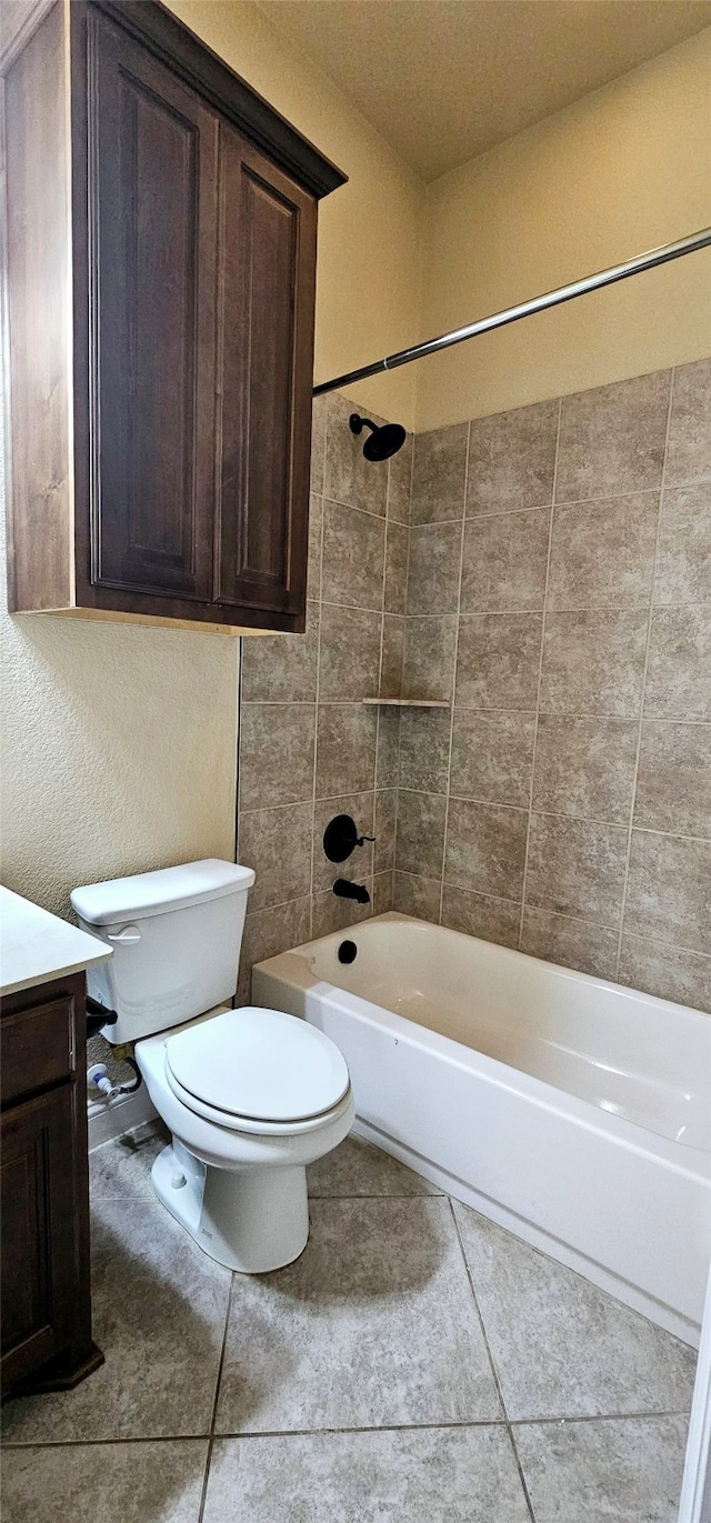 full bathroom with tile patterned floors, vanity, tiled shower / bath combo, and toilet