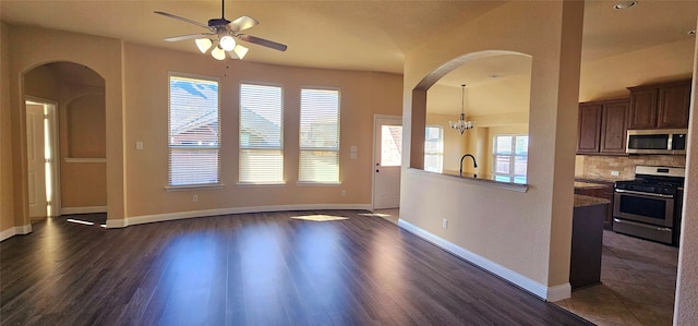 interior space featuring backsplash, a healthy amount of sunlight, stainless steel appliances, and dark wood-type flooring