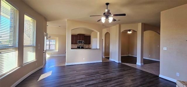 unfurnished living room featuring ceiling fan and dark hardwood / wood-style flooring