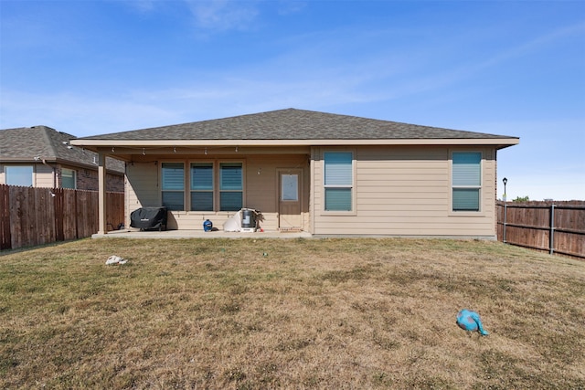 back of house with a patio and a lawn