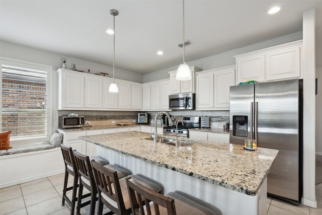 kitchen featuring appliances with stainless steel finishes, white cabinetry, sink, and pendant lighting