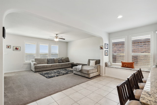 living room with ceiling fan, plenty of natural light, and light tile patterned floors