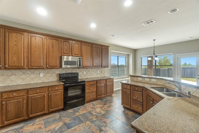 kitchen with visible vents, decorative backsplash, stainless steel microwave, black / electric stove, and a sink