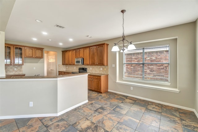 kitchen featuring black electric range, a notable chandelier, decorative light fixtures, and tasteful backsplash