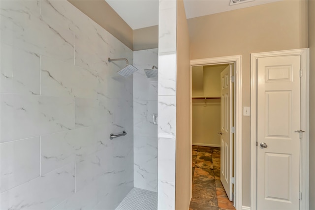 bathroom with a marble finish shower, visible vents, and a walk in closet