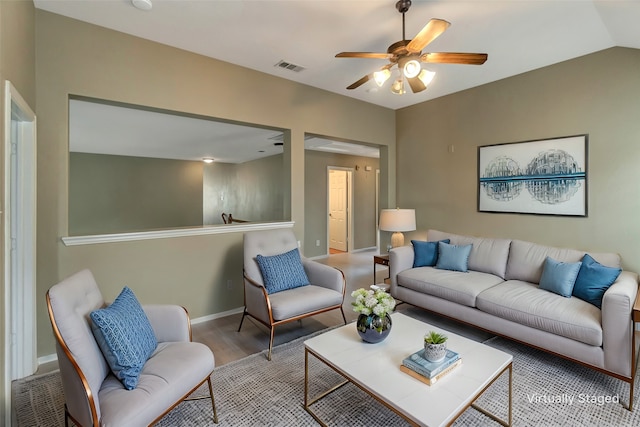 living area featuring lofted ceiling, wood finished floors, a ceiling fan, visible vents, and baseboards