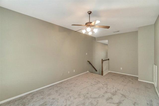 unfurnished room with baseboards, light colored carpet, visible vents, and a ceiling fan