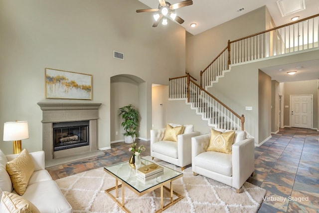 living room featuring ceiling fan and a high ceiling