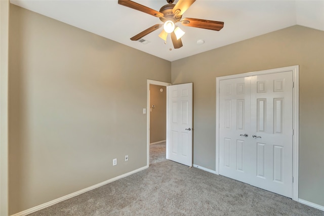 unfurnished bedroom featuring a closet, ceiling fan, lofted ceiling, and light colored carpet