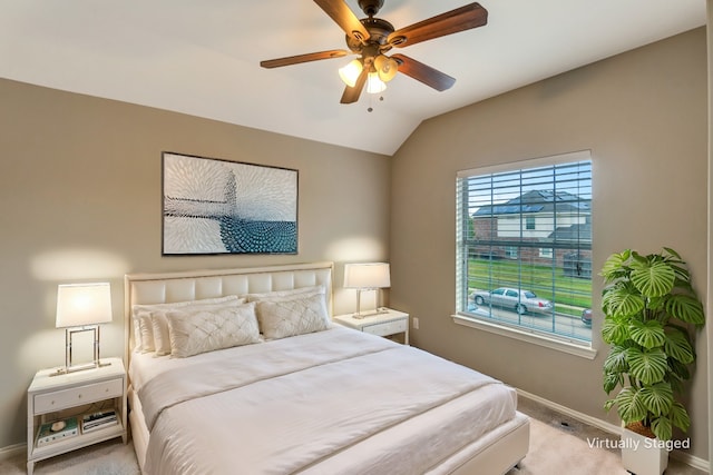 carpeted bedroom with vaulted ceiling, a ceiling fan, and baseboards