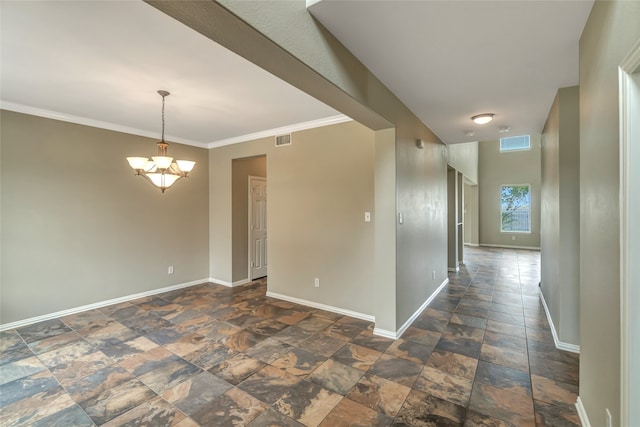 empty room featuring crown molding and an inviting chandelier