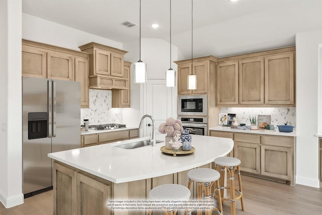 kitchen with light wood-style flooring, tasteful backsplash, visible vents, appliances with stainless steel finishes, and a sink