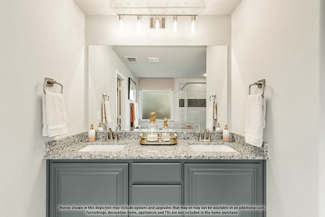 bathroom with vanity and a shower with door