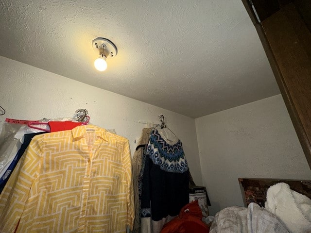 bedroom featuring lofted ceiling and a textured ceiling