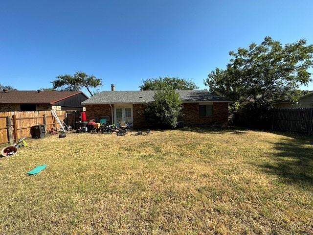 rear view of house featuring a lawn