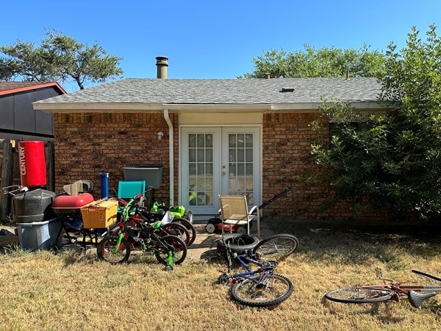 rear view of property featuring french doors and a lawn