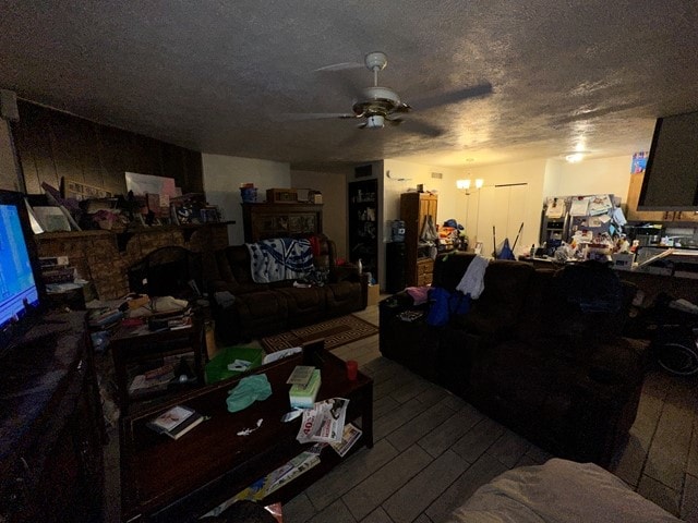 living room with a textured ceiling, hardwood / wood-style floors, and ceiling fan with notable chandelier