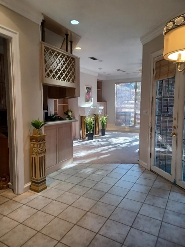 interior space with ornamental molding and light tile patterned floors