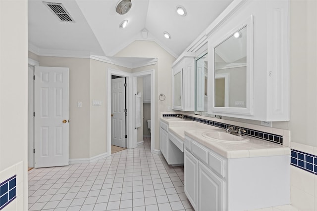 bathroom with ornamental molding, lofted ceiling, tile patterned flooring, and vanity