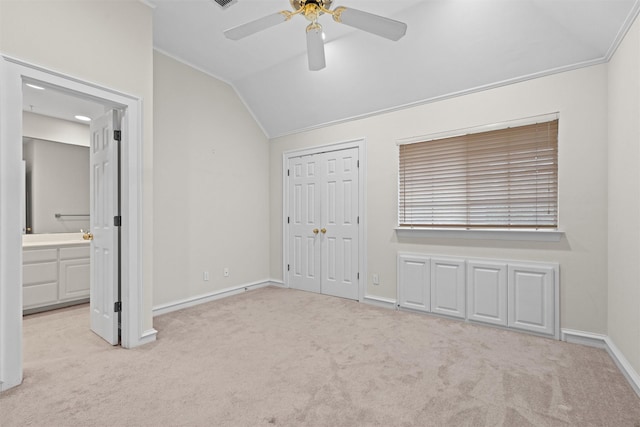 unfurnished bedroom with light colored carpet, ceiling fan, crown molding, and vaulted ceiling