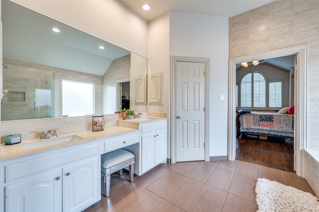 bathroom featuring hardwood / wood-style floors, tile walls, vaulted ceiling, vanity, and an enclosed shower