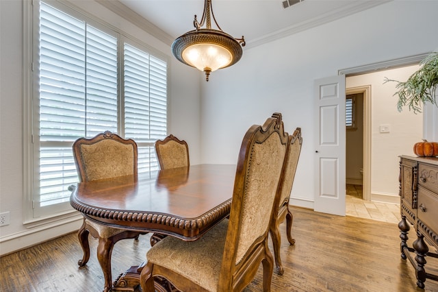 dining space featuring light hardwood / wood-style floors and ornamental molding