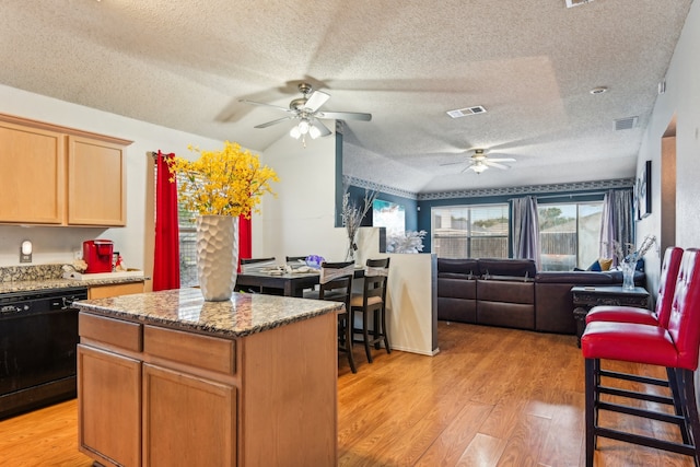 kitchen featuring black dishwasher, a kitchen island, a textured ceiling, and lofted ceiling