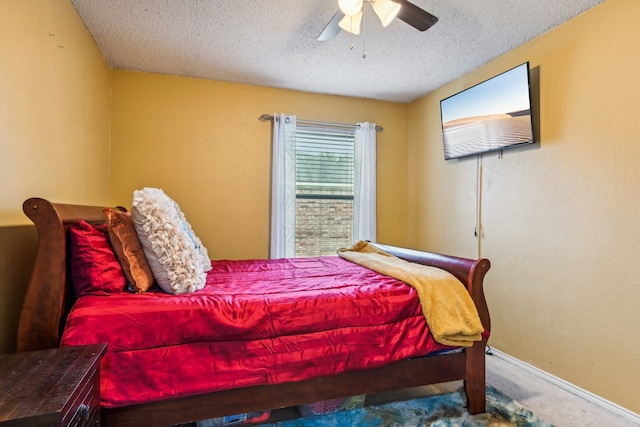 carpeted bedroom featuring ceiling fan and a textured ceiling